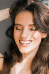Naklejka premium Portrait of smiling young brunette woman, model, closes eyes.