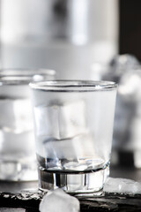 Cold Vodka in shot glasses on black background, ready to drink