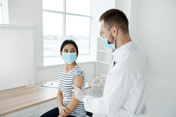 woman in medical mask vaccination in hospital health protection
