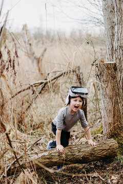 Little girl with virtual reality glasses in a forest