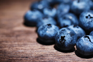 Water drops on ripe sweet blueberry. Fresh blueberries background with copy space for your text. Vegan and vegetarian concept. Macro texture of blueberry berries.