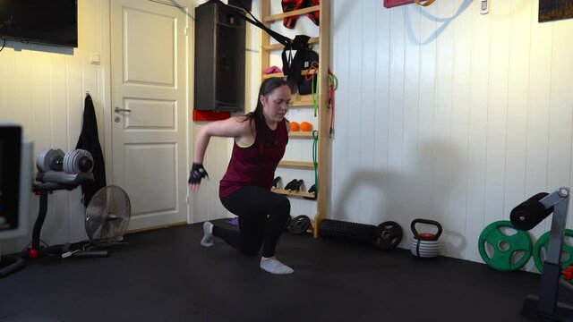 Woman performing lunges strength excercise in her homemade gymnasium - Stay fit during covid quarantine