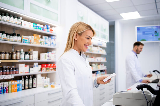 Female caucasian pharmacist selling medicines in pharmacy store.