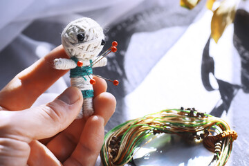 Voodoo Doll on a stone background with dramatic lighting. Mystic still life with voodoo doll and witchcraft objects.