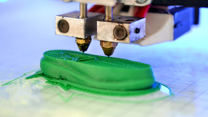 3D printer prints the form of molten plastic green.