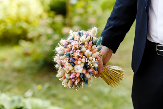 Bouquet of dried flowers in the hands of the man