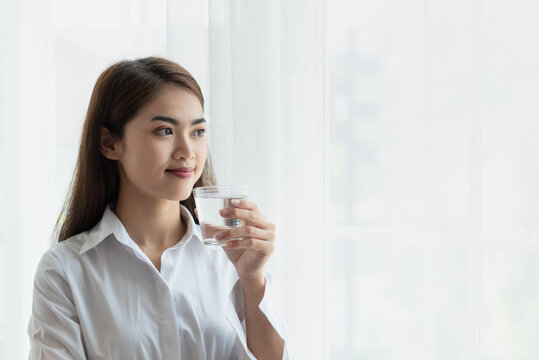 Young Asian Woman Holding Glass Of Water