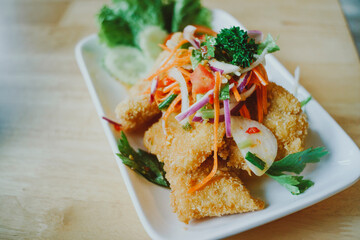 Spicy deep fried catfish salad in the dish put on the table