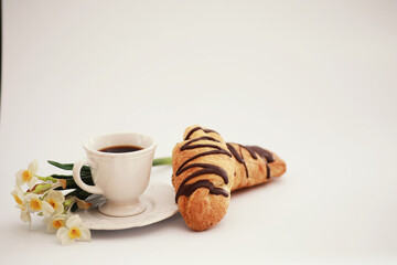 French breakfast on the table. Coffee croissant with chocolate and a decanter with cream. Fresh pastries and decaffeinated coffee.
