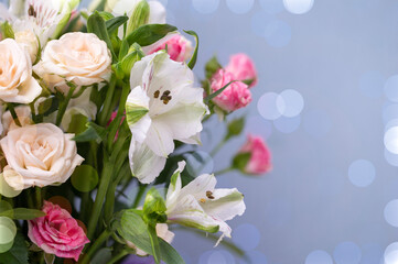 Beautiful flowers close-up in pastel colors on a blue background with bokeh. Greeting card, mom's day, wedding invitation, birthday. Copy of the place.