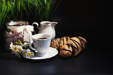 French breakfast on the table. Coffee croissant with chocolate and a decanter with cream. Fresh...