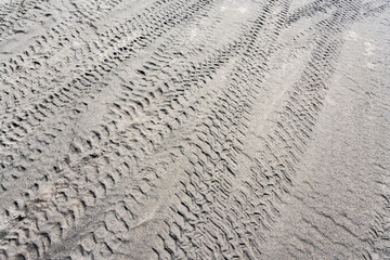 Tire tracks on the sand in desert. Sand texture background.