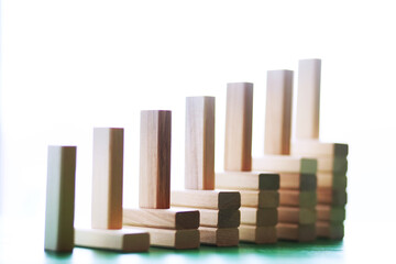 Stick wood block standing on stacked square wood blocks, abstract background in concept of winning, success, challenge, step to top position.