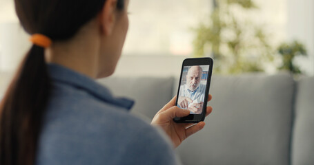 Woman video calling her doctor with her smartphone