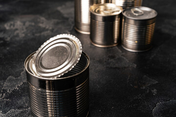 Tin cans with conserved food on gray surface