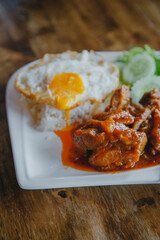 steamed pork and rice with A fried egg on wood table