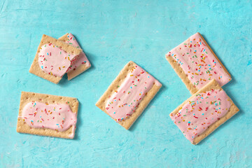 Strawberry pop tarts, overhead flat lay shot on a blue background