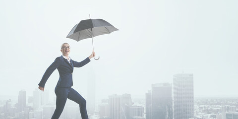 Young businesswoman walking with umbrella