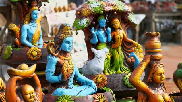 Beautiful handcrafted idols of Indian gods are out for sale in the local market of Delhi/NCR  India. Closeup shot of different showpieces of Lord Shiva  Radha Krishna  and other decoratives in an o...