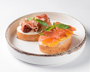 Juicy tomatoes and fresh fruit with carpaccio meat on fresh bread, sauce as topping. Traditional Italian cuisine.