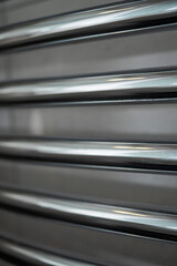 Stainless steel metal towel dryer in a bathroom with grey stone wall. High end grade equipment in a...