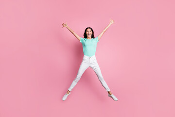 Fototapeta na wymiar Full size photo of young charming lovely excited crazy smiling girl jumping in victory isolated on pink color background