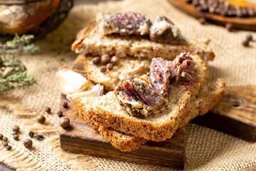 Toast with homemade beef stew on a wooden board on a brown rustic table