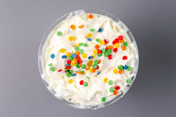 milkshake with bright confetti top view on gray background