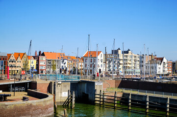 View of the harbor with sailing yachts and historical houses in the background. Location is the dutch town Vlissingen in the province Zeeland. Popular town for beach and summer.
