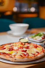 Margherita Pizza served in restaurant or pizzeria. Photo with blurred background. Traditional Italian cuisine concept.