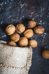 Bag with walnuts, home harvest on a dark background. Top view