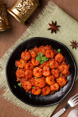 Top view spicy hot Bengali Prawn roast , shrimp masala fish curry. Indian food. Flat lay of fish fry red chili, curry leaf. Asian cuisine, Kerala fish, Goan fish curry clay pot. Grilled tiger shrimps