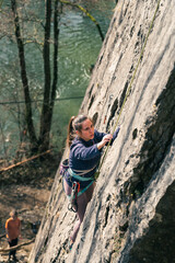 Young female climber concentrates on her next move on the climbing route.