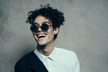 happy man dazzling smile curly hair glasses model shirt jacket