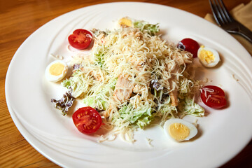 Chicken breast salad with parmesan cheese, eggs and tomatoes. Close-up, selective focus