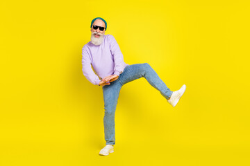 Photo of cute sweet age gentleman wear violet sweater headwear dark glasses smiling dancing isolated yellow color background
