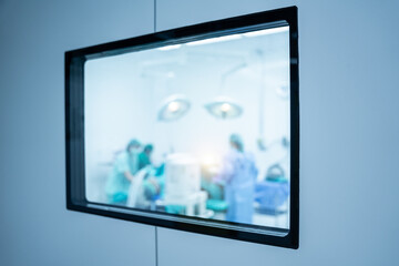 blurred through the door glass of the surgeons in operating room.