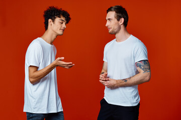 Two cheerful friends in white t-shirts communication isolated background fun