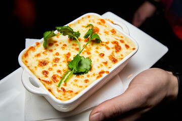 Baked chicken fillet with potatoes and cream cheese sauce. Close-up, selective focus