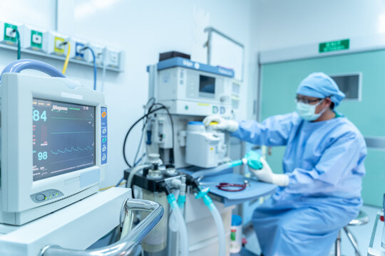 Selective focus of monitor, assistant working heart rate monitor surgeon's team in uniform performs an operation on a patient at a cardiac surgery, Life-saving devices in surgery, Surgical equipment
