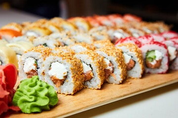 Set of various sushi rolls on a board. Close-up, selective focus