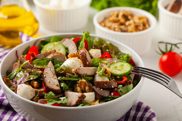 Salad with pork tenderloin, fresh cucumber and mozzarella.