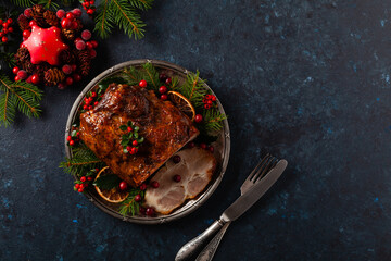 Roast pork neck in Christmas style. Dark navy blue background. Christmas accessories. Top view.