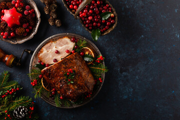 Roast pork neck in Christmas style. Dark navy blue background. Christmas accessories. Top view.