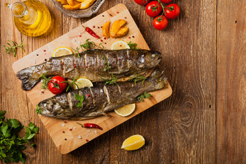 Fototapeta na wymiar Grilled whole trout. Served with baked potatoes.