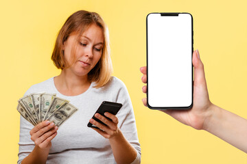 A young woman holds a fan of dollars and a cellphone. On the right is a smartphone with a white screen. Mock up. Yellow background. Online Shopping concept