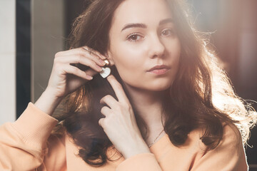 Fototapeta premium close up of beautiful woman puts on heart shaped earrings