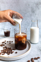 person pouring milk in coffee decoction - morning coffee