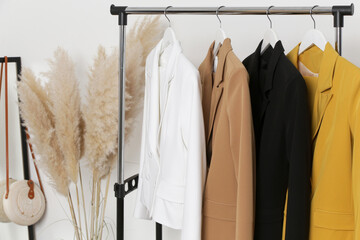Corner in fashion atelier with fashionable tailored blazers hanging on a rack. Modern premium...