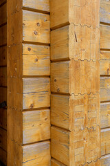 Glued timber for a wooden house, with knots and scratches, light wood texture for the background.
